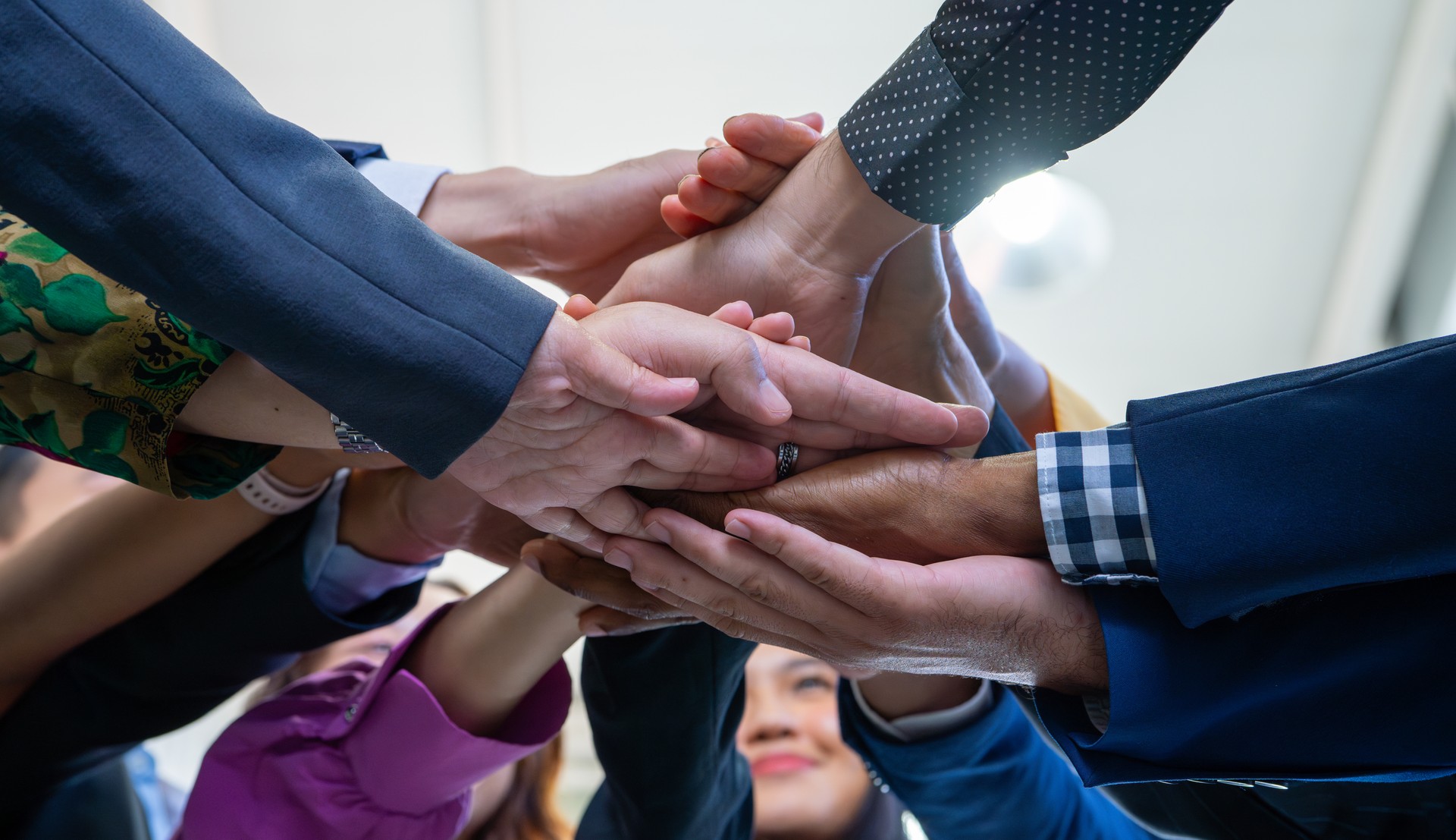 Team, teamwork, and unity concept. Diverse team putting hands together. Group of diverse business people. Working together as a team. Partnership and togetherness create a strong sense of community.