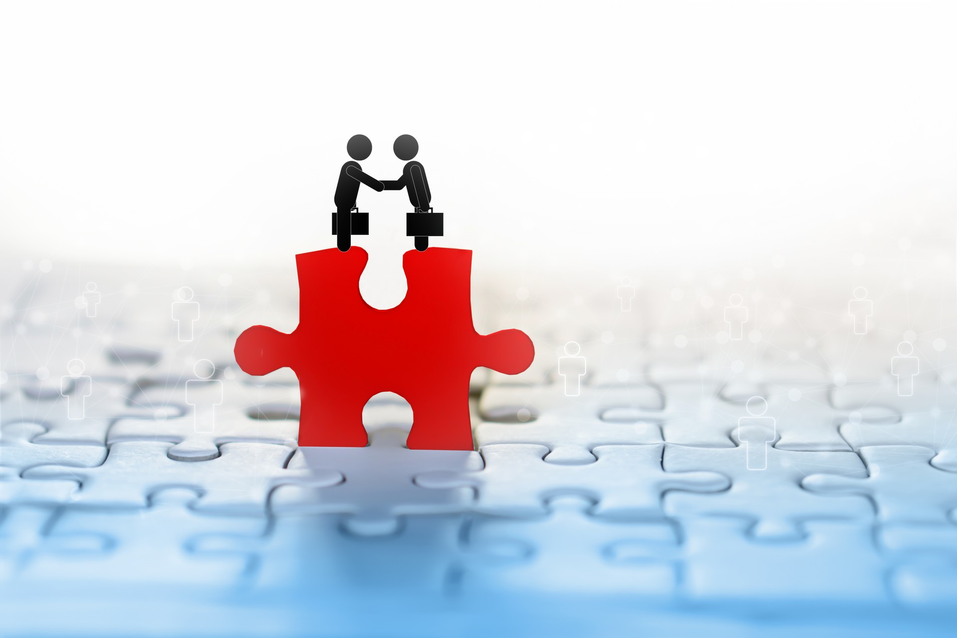 two businessman handshake icon on red jigsaw with people connection in background idea for business teamwork,